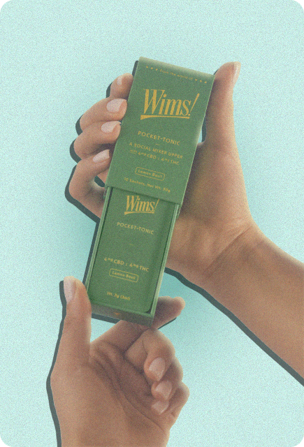 Two hands holding a Lemon Basil Wims Pocket-Tonic THC/CBD drink mixer against a light blue background.