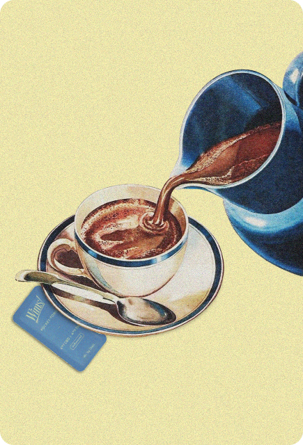 A blue pitcher pours rich hot chocolate into a white cup on a matching saucer, with a silver spoon beside it and a Wims Pocket-Tonic sachet resting nearby.