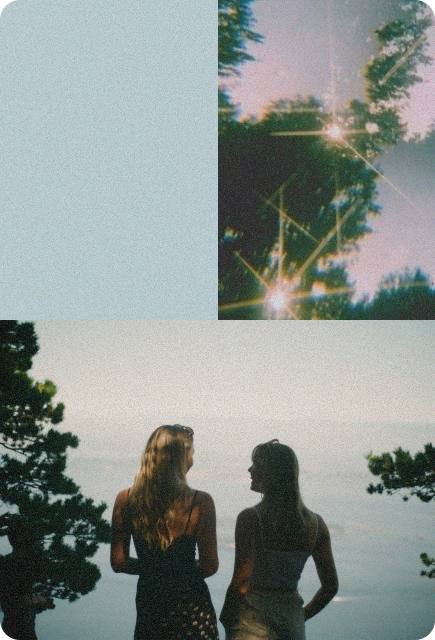 Two women standing outdoors in soft sunlight, surrounded by trees and lens flares, evoking carefree joy and connection.