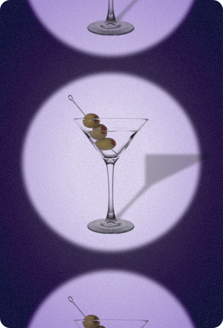 Martini glass with olives centered under spotlight circles, representing a non-alcoholic Dirty Martini made with Wims.