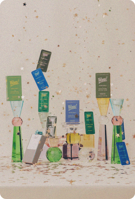 A festive arrangement of Wims Pocket-Tonic balanced on colorful glassware, surrounded by small gift boxes and scattered gold star confetti on a neutral background.