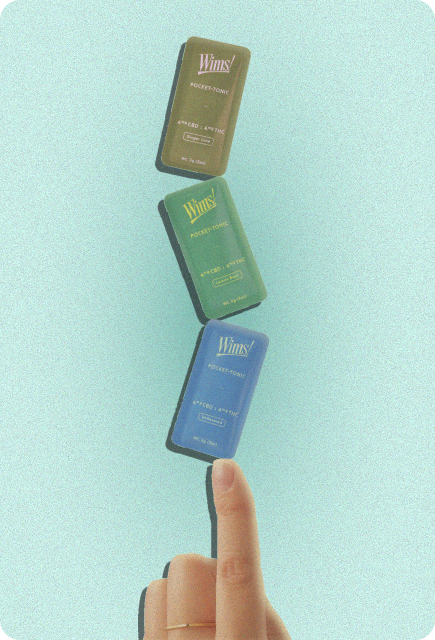 Three Wims Pocket-Tonic THC/CBD drink mixers balanced on a finger against a light blue background.