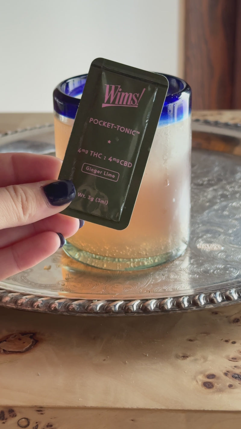 Hand snapping open and pouring a Ginger Lime Pocket-Tonic into a glass of iced blood orange juice, then gently stirring to combine the citrus flavors.