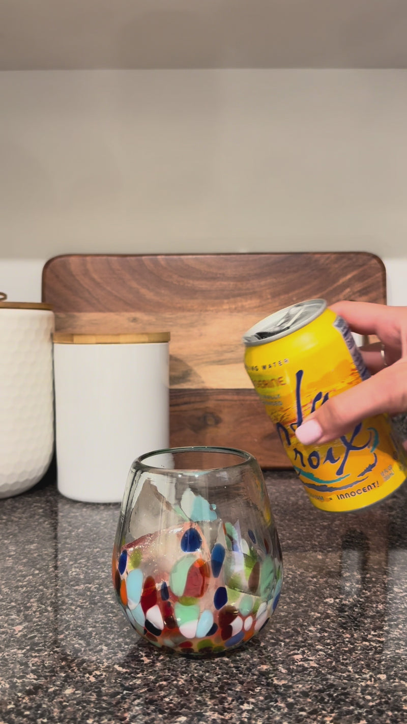 Sparkling water being poured into the strawberry and orange mixture over ice for a light, bubbly finish.