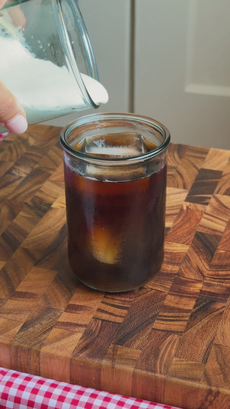 Creamy whipped foam being poured over the espresso and Diet Coke mixture to finish the Wims Fridge Cig.