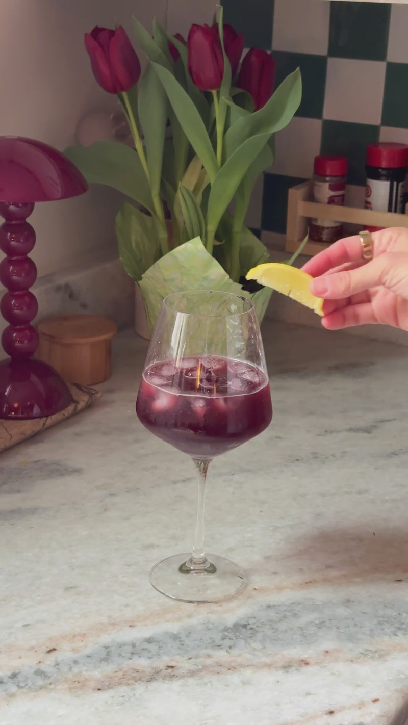 Finished Sleepy Spritz garnished with a fresh lemon wedge in a stemmed wine glass.