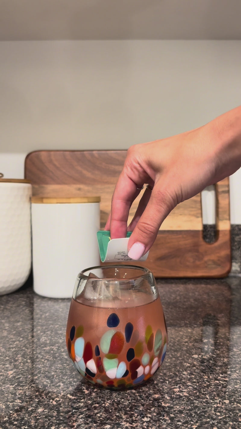 Lemon Basil Wims Pocket-Tonic™ being added to the Strawberry Sunset Mocktail and stirred with a glass straw.
