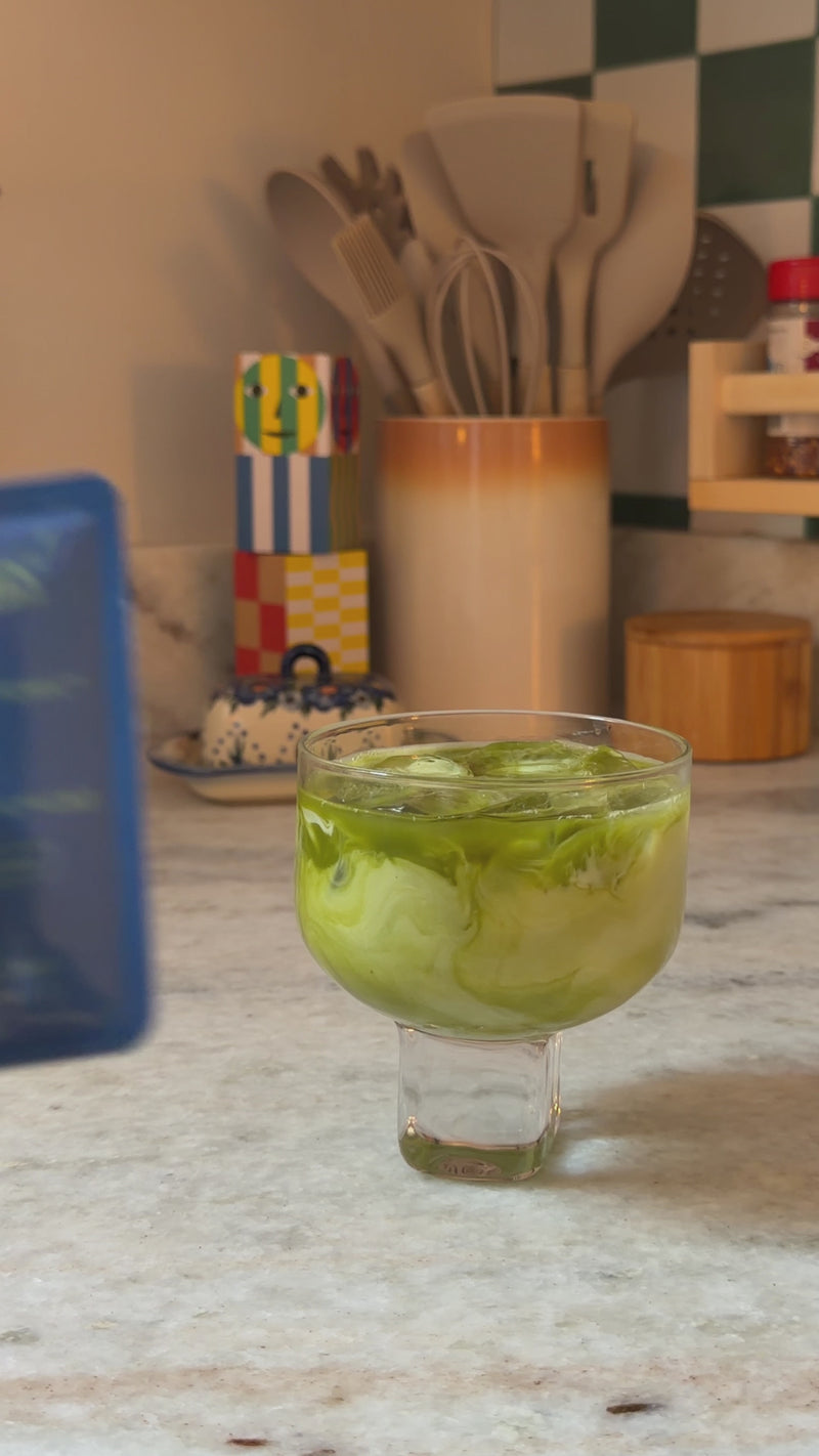 Wims Pocket-Tonic™ being added to an iced matcha latte, then stirred to combine.